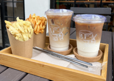 Two milktea and fries on a wooden tray